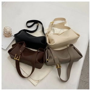 Detailed overhead shot showing four colors of lychee grain leather pillow bags on white fabric