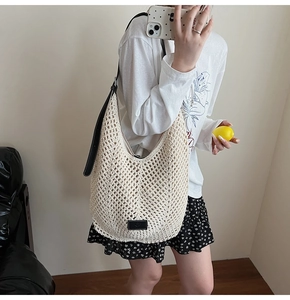Détail du sac à bandoulière évidé avec sangle en cuir noir et écusson logo élégant