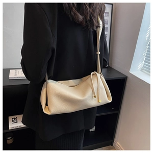 Detail view of cream lychee texture crossbody bag with gold heart zipper charm