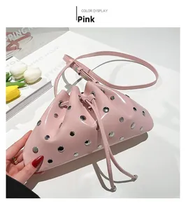 Detailed view of pink drawstring bucket bag with silver studs and glossy leather finish