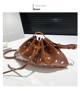 Detail view of brown glossy patent leather bucket bag with silver stud accents