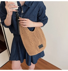 Détail d'un sac bandoulière tissé à la main en maille marron avec bandoulière en cuir noir