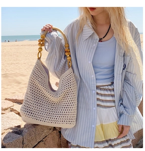 Detail of hand-woven hobo beach bag featuring natural wooden bead handle and large capacity