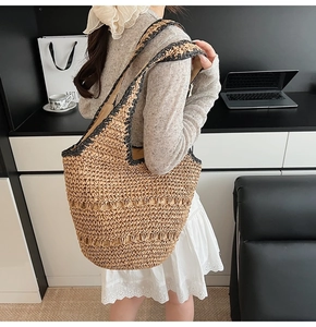 Macro detail of natural straw bucket bag featuring contrast black trim and hollow woven patterns