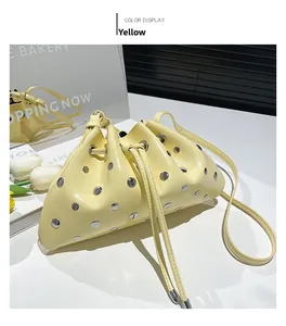 Detailed macro of a yellow matte leather bucket bag with silver rivet studs and drawstring