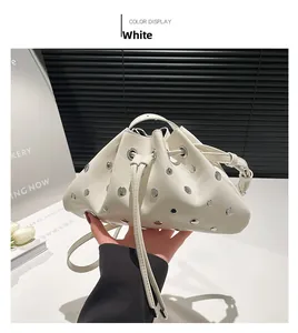 Detail of white leather bucket bag with silver metal eyelets and drawstring closure