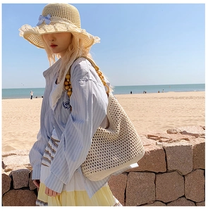 Detail of hand-woven straw beach bag featuring unique wooden bead shoulder straps