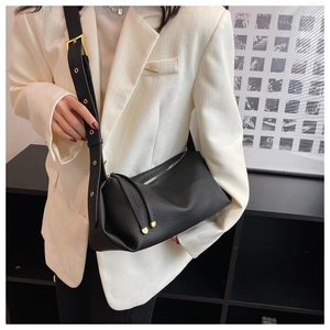 Detail of black lychee leather crossbody bag with adjustable strap and gold hardware