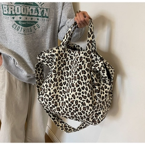 Detail of leopard print canvas tote bag with wide shoulder strap and dual handles