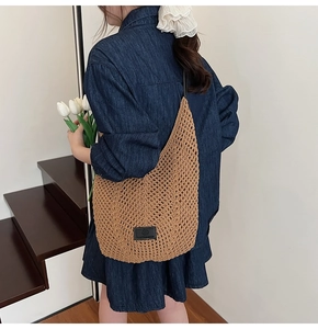 Détail du sac cabas en tricot ajouré marron clair avec écusson en cuir noir et bandoulière