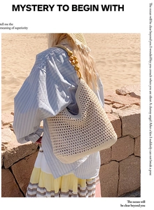Detail of woven tote bag with wooden bead straps on a sunny beach setting
