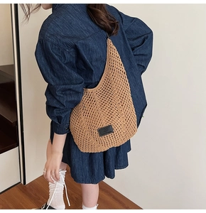 Detailed side view of handcrafted brown hollow-out woven shoulder bag on model