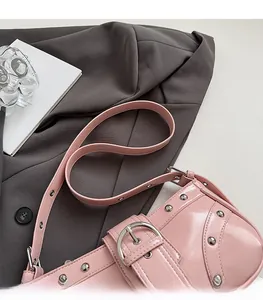 Détail du sac sous l'aisselle en cuir rose brillant avec rivets argentés et boucle