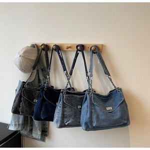 Detail view of denim tote bags in four vintage washes with metal chain straps