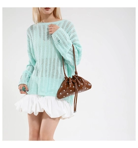 Detail view of a brown drawstring bag with silver metal studs and mint crochet knitwear