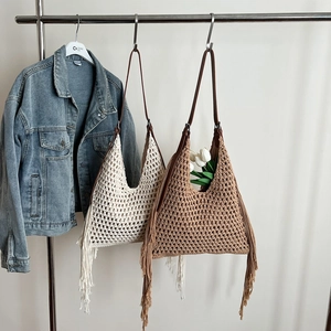 Handgefertigte Boho-Webtasche mit Fransen und Lederriemen in minimalistischer Umgebung
