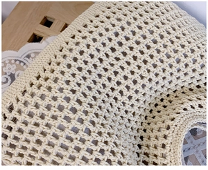 Macro shot of handmade crochet weave detail showing intricate hollow mesh texture and cream yarn