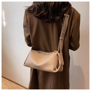 Detail of minimalist beige pebble leather crossbody bag with adjustable wide strap