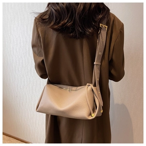 Detail of taupe litchi grain leather crossbody bag with golden hardware and wide strap