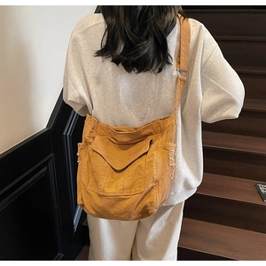 Close-up of large canvas shoulder bag with raw edge texture and front flap pocket
