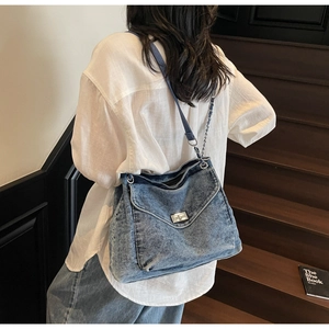 Détail du sac cabas en jean vintage avec chaîne argentée et fermoir pivotant en métal