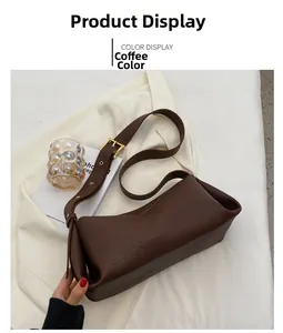 Detailed close-up of brown pebbled leather texture and gold hardware on a retro shoulder bag