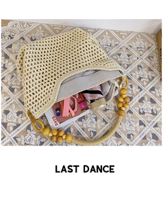 Detail of hand-woven beige tote bag with wooden bead handle and functional zipper lining