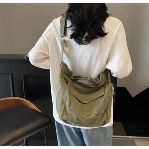 Back view of a large military green canvas messenger bag featuring raw edge pocket details