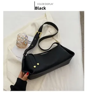 Close-up of black crossbody pillow bag with lychee grain texture and leather tassel