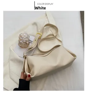 Detail view of cream white pebbled leather bag with premium gold zipper and hardware