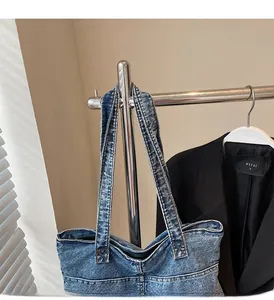 Detail of vintage blue denim tote bag with reinforced handles and zipper closure