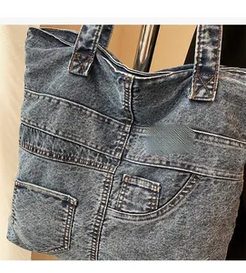 Detail of blue denim tote bag featuring multiple pockets and white stitching accents