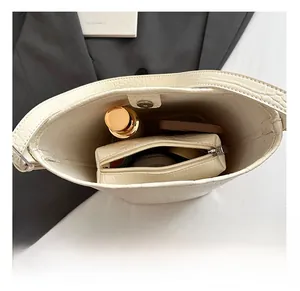 Interior view of white crocodile pattern bucket bag with a zippered inner pouch and magnetic snap