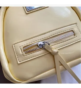 Macro shot of smooth silver metal zipper with cream yellow leather puller detail