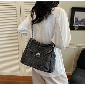 Détail du sac cabas en jean délavé avec boucle métallique et bandoulière chaîne