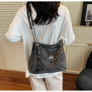 Gros plan du sac fourre-tout en denim gris avec chaîne et détail du fermoir rotatif