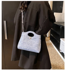 Sac à bandoulière bleu clair texture denim avec fermoir tournant en métal argenté