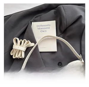 Detail showing creamy white crocodile texture leather bag with detachable shoulder strap