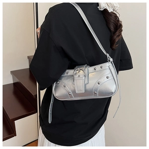 Gros plan d'un sac à bandoulière argenté avec rivets décoratifs et boucles métalliques