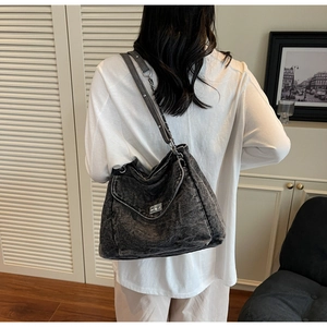 Détail du sac hobo en denim gris avec boucle argentée et bandoulière chaîne et cuir
