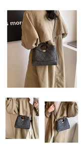 Détail du sac matelassé gris foncé avec poignée ronde en métal et fermoir tournant argenté