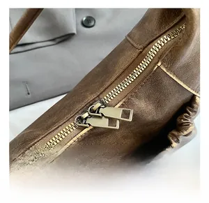 Detail of premium double metal zippers and brown pleated leather on vintage baguette bag