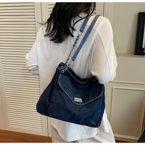 Détail du sac cabas en jean bleu marine avec sa texture et sa bandoulière en chaîne
