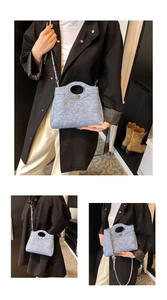 Détail du sac seau en denim bleu avec poignée ronde évidée et bandoulière chaîne argent