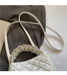 Close-up of diamond quilted bag with sparkling rhinestones and woven handle detail