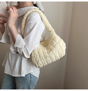 Detalle del bolso hobo amarillo acolchado con textura de burbujas y correa integrada