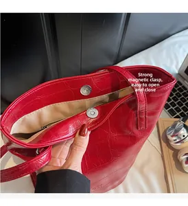 Detail of red crocodile pattern tote with magnetic closure and inner zipper pocket