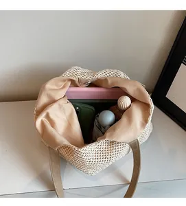 Detail showing internal capacity of large straw tote bag with laptop and daily essentials