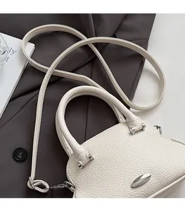 Detail of lychee pattern cream white leather handbag with elegant silver metal closure
