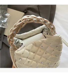 Detail of white quilted handbag with crystal studs and braided chain handle